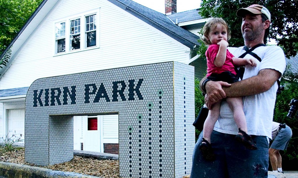 Artist Sean R. Ward and son posing with the new sign